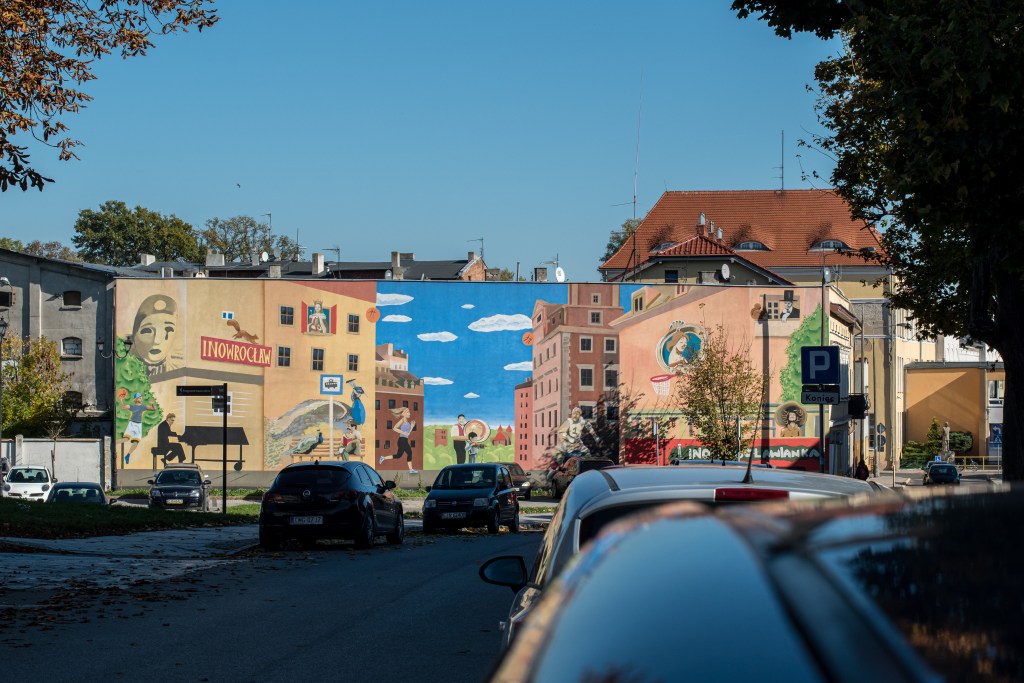 Mural "Inowrocław w pigułce". W tle pomnik Jana Kasprowicza